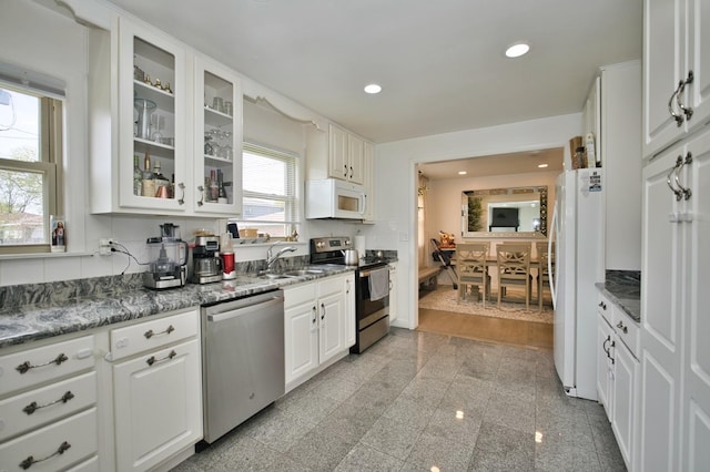 5025 Jerome Ave, Skokie, IL 60077 - kitchen with stainless steel appliances, a sink, white cabinets, glass insert cabinets, and recessed lighting