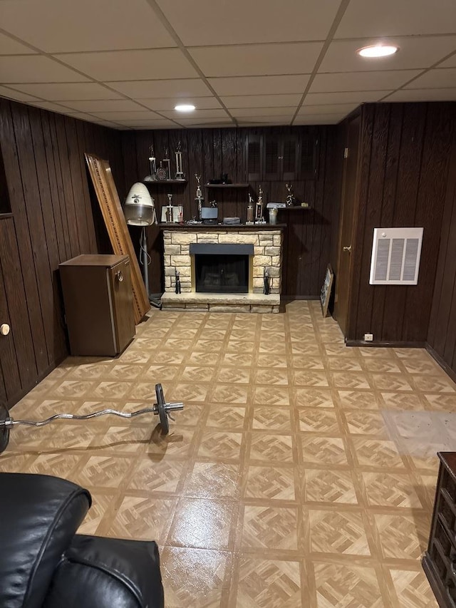 1214 E 165th St, South Holland, IL 60473 - living area with wood walls, a drop ceiling, a stone fireplace, light flooring, and recessed lighting