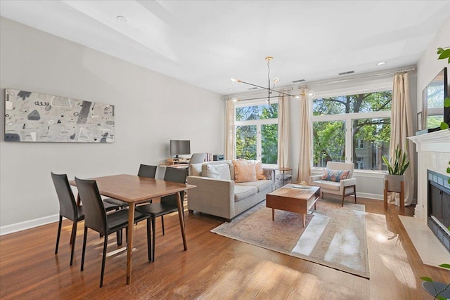 3616 N Janssen Ave Unit 2N, Chicago, IL 60613 - dining space featuring a chandelier, wood finished floors, a tiled fireplace, and baseboards