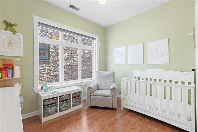 3616 N Janssen Ave Unit 2N, Chicago, IL 60613 - bedroom with a nursery area, baseboards, and wood finished floors