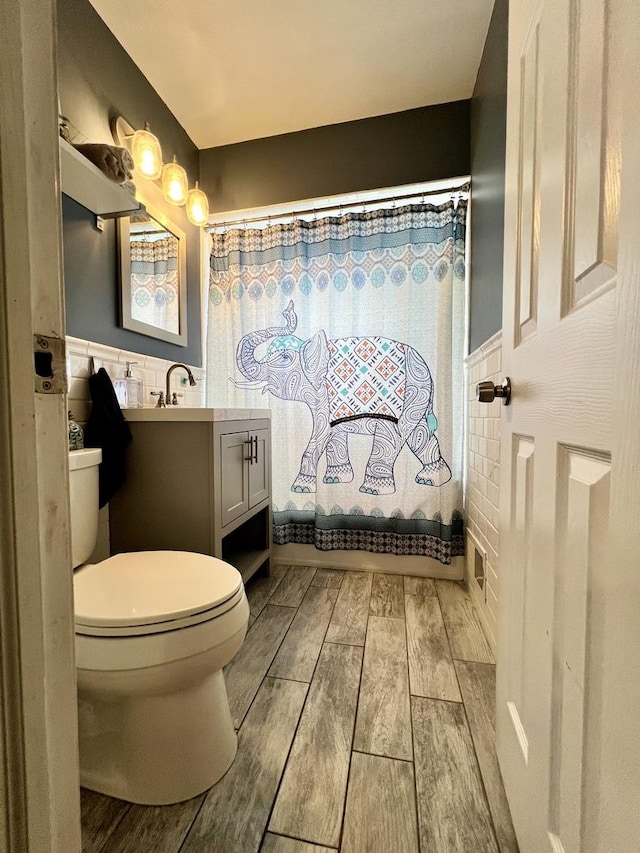 8605 Leclaire Ave, Burbank, IL 60459 - full bath featuring toilet, wood finished floors, vanity, a wainscoted wall, and shower / bath combo