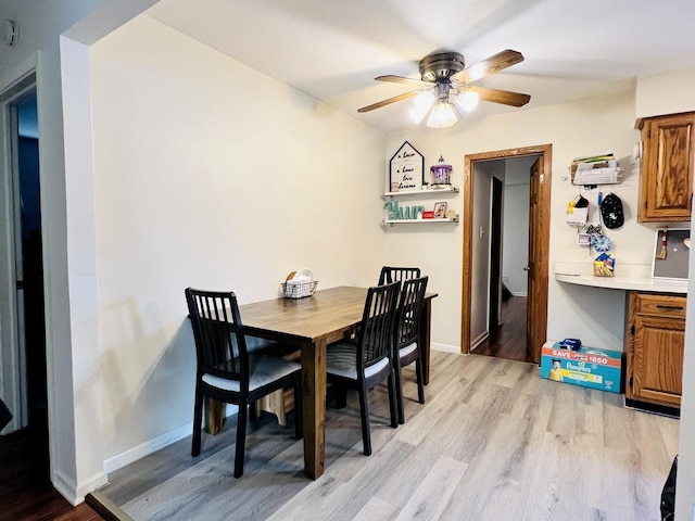 8605 Leclaire Ave, Burbank, IL 60459 - dining area with light wood-style floors, a ceiling fan, and baseboards