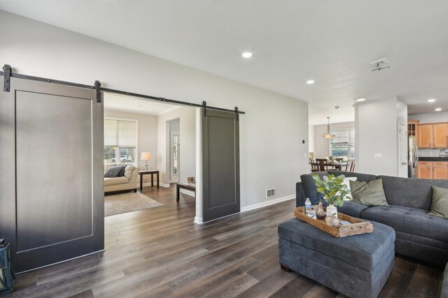 1159 Clover Hill Ln, Elgin, IL 60120 - living room featuring a barn door, recessed lighting, dark wood-style flooring, and baseboards