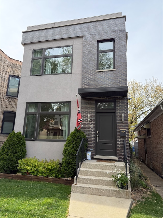 contemporary home with brick siding and stucco siding