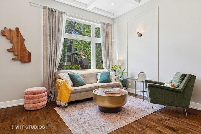 living area featuring baseboards, wood finished floors, coffered ceiling, and beamed ceiling