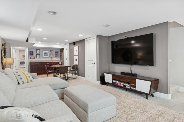 living area featuring light carpet, baseboards, and recessed lighting