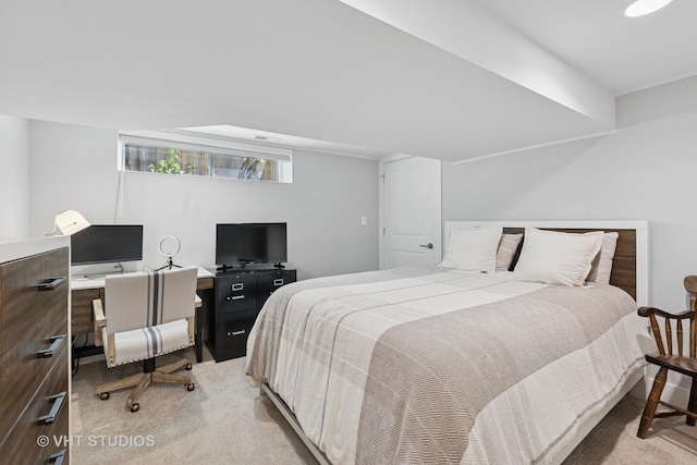 bedroom with light carpet and a desk