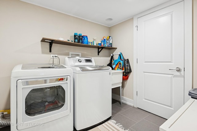 laundry room with washer and clothes dryer, tile patterned floors, and baseboards