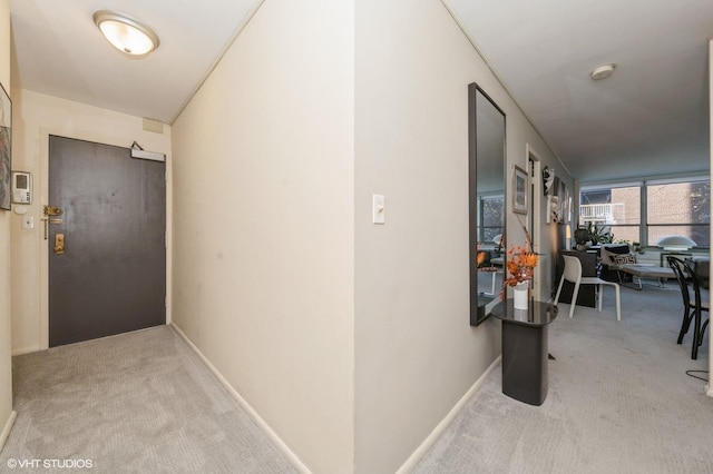hallway with carpet floors and baseboards