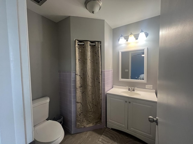 18840 May Ave, Homewood, IL 60430 - bathroom with vanity, wood finished floors, curtained shower, tile walls, and a wainscoted wall