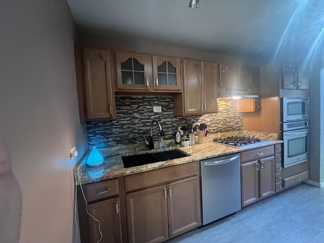 18840 May Ave, Homewood, IL 60430 - kitchen featuring appliances with stainless steel finishes, decorative backsplash, light stone countertops, and glass insert cabinets