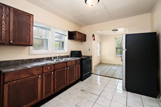 1990 Patrick Ave, Kankakee, IL 60901 - kitchen featuring electric range, freestanding refrigerator, a sink, dark countertops, and dark brown cabinetry