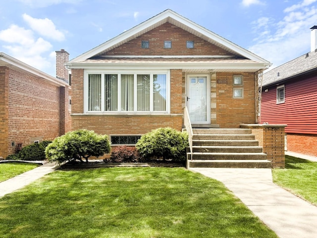 view of front of home with a front yard and brick siding