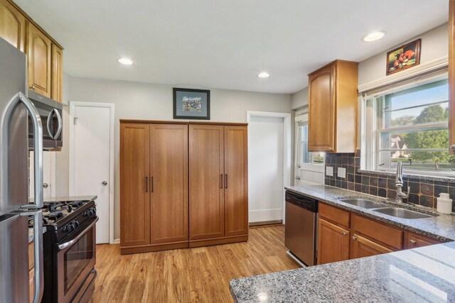 110 W Maude Ave, Arlington Heights, IL 60004 - kitchen with appliances with stainless steel finishes, a sink, light wood finished floors, brown cabinets, and stone countertops