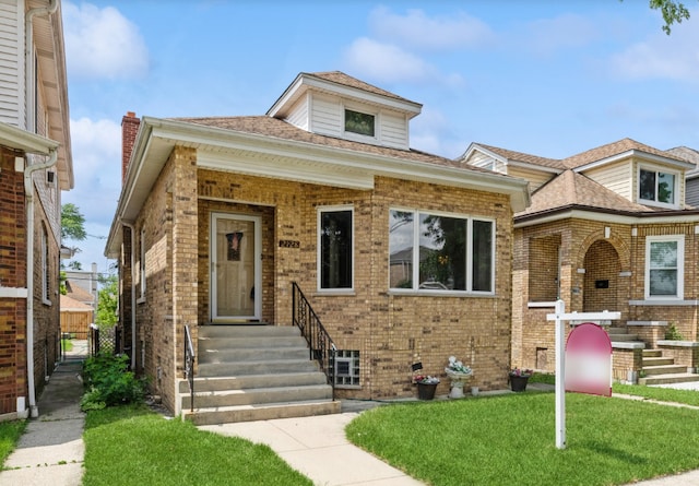 view of front facade featuring brick siding and a front yard