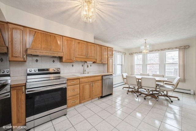 kitchen featuring stainless steel appliances, a chandelier, premium range hood, light countertops, and a sink