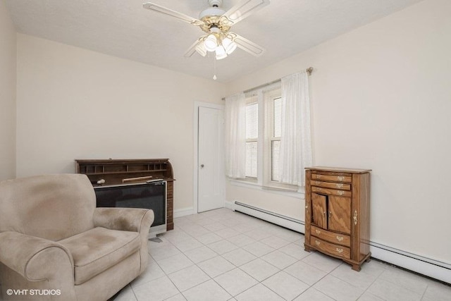 sitting room with a baseboard radiator, a ceiling fan, light tile patterned flooring, and baseboards