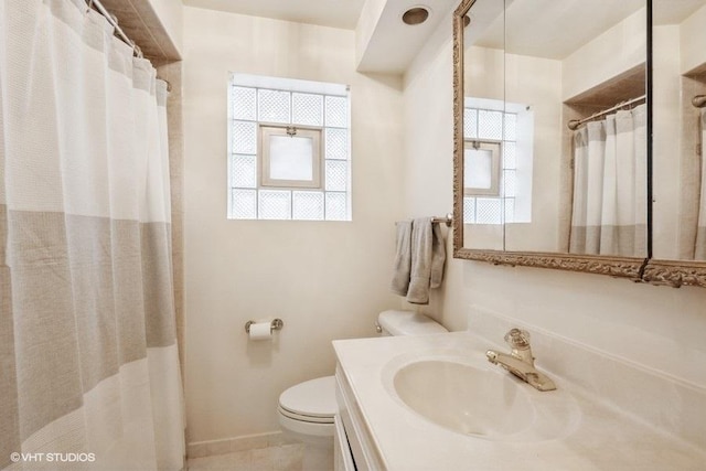 full bath featuring toilet, plenty of natural light, vanity, and baseboards