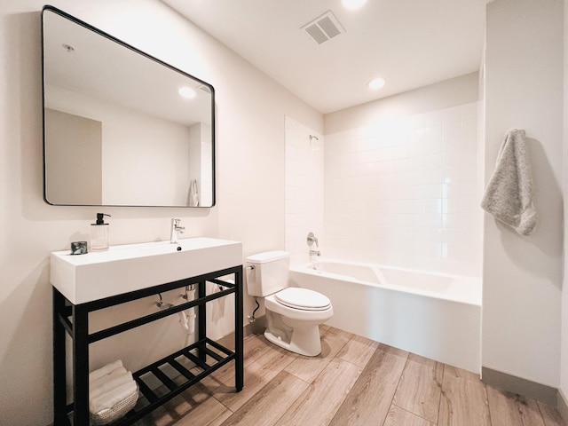 full bathroom with toilet, wood finished floors, washtub / shower combination, vanity, and baseboards