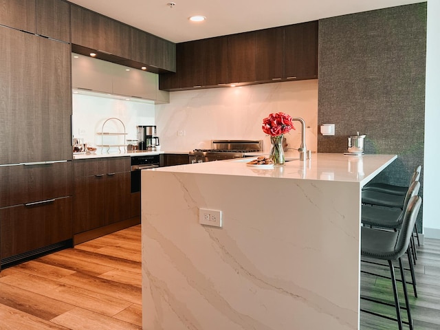 kitchen with range, a peninsula, modern cabinets, dark brown cabinetry, and recessed lighting