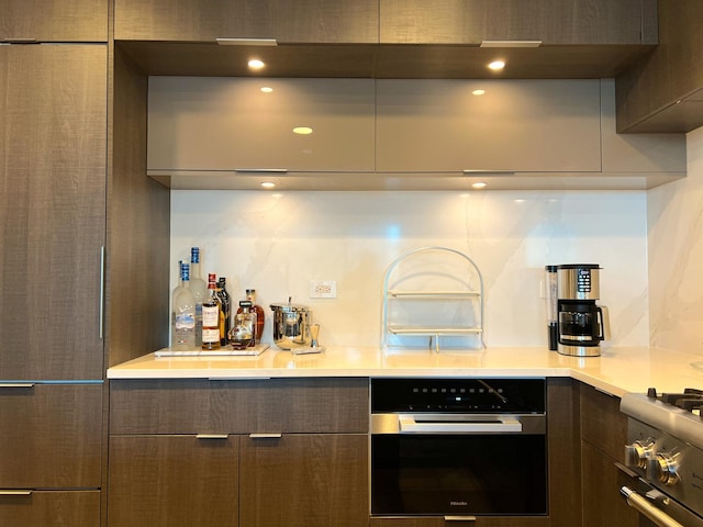 kitchen featuring modern cabinets, oven, and light countertops