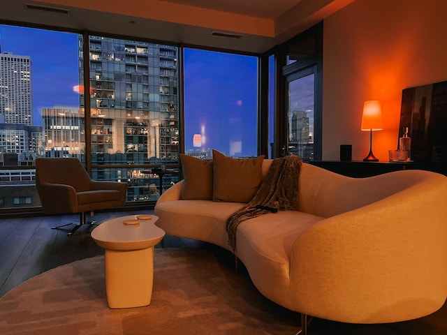 interior space featuring a city view, a wall of windows, a dry bar, and wood finished floors