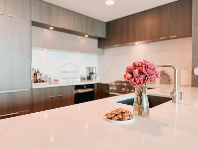 kitchen featuring oven, light countertops, recessed lighting, a sink, and modern cabinets