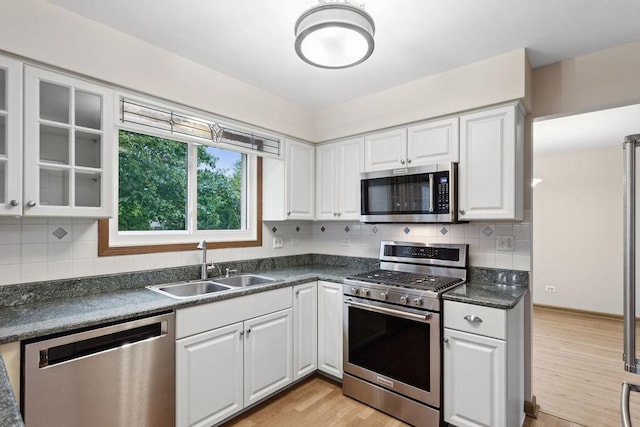 1836 71st St, Woodridge, IL 60517 - kitchen featuring stainless steel appliances, a sink, dark countertops, white cabinets, and light wood finished floors