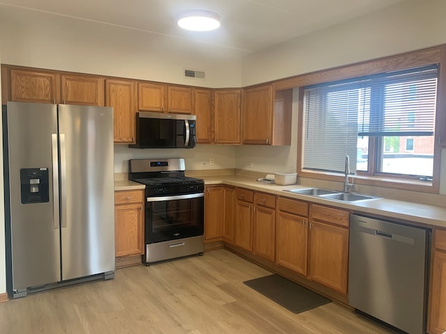 1327 E Washington St Unit 207, Des Plaines, IL 60016 - kitchen with stainless steel appliances, a sink, light countertops, and light wood-type flooring
