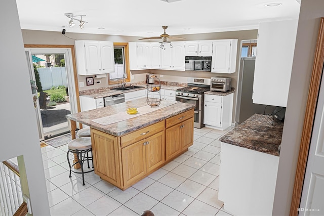19634 Patricia Ln, Mokena, IL 60448 - kitchen with appliances with stainless steel finishes, a sink, ornamental molding, white cabinets, and a kitchen breakfast bar
