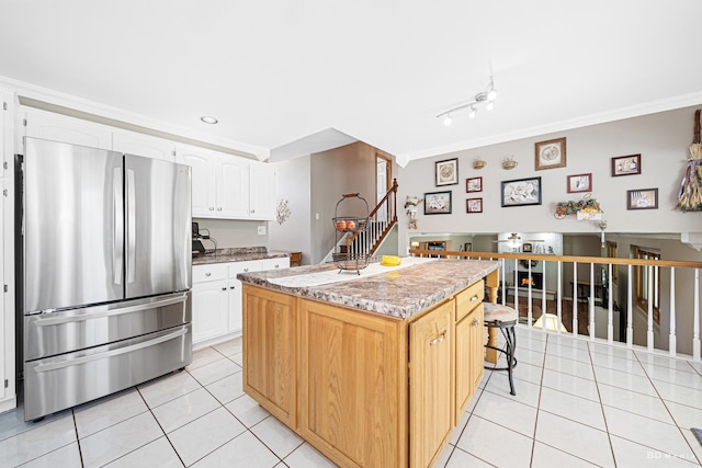 19634 Patricia Ln, Mokena, IL 60448 - kitchen featuring freestanding refrigerator, light tile patterned floors, ornamental molding, a center island, and white cabinets