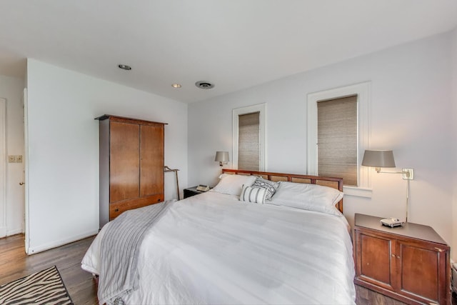 bedroom with wood finished floors, recessed lighting, and baseboards