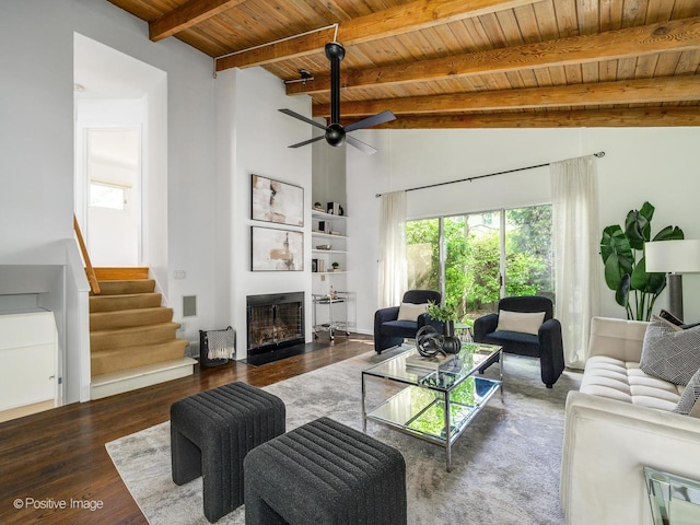 living area featuring wood finished floors, wood ceiling, a fireplace, stairs, and a ceiling fan