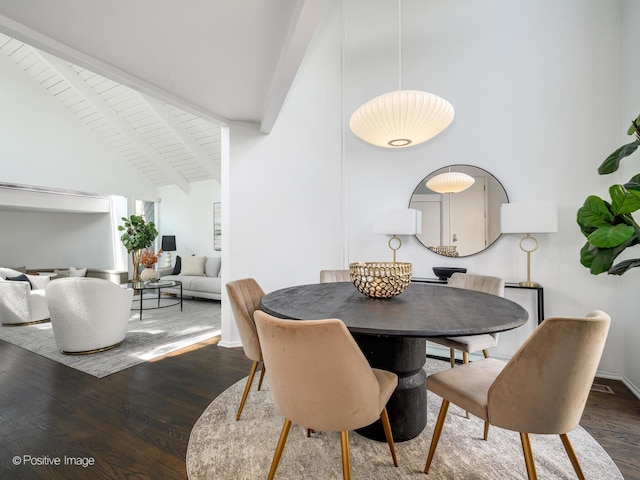 dining space featuring beam ceiling, wood finished floors, and high vaulted ceiling