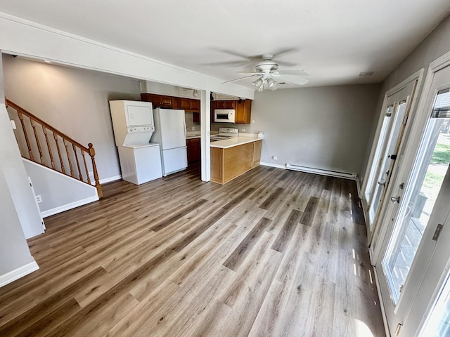 35 Montego Colony Unit 1, Fox Lake, IL 60020 - unfurnished living room with baseboard heating, stairway, wood finished floors, a ceiling fan, and baseboards