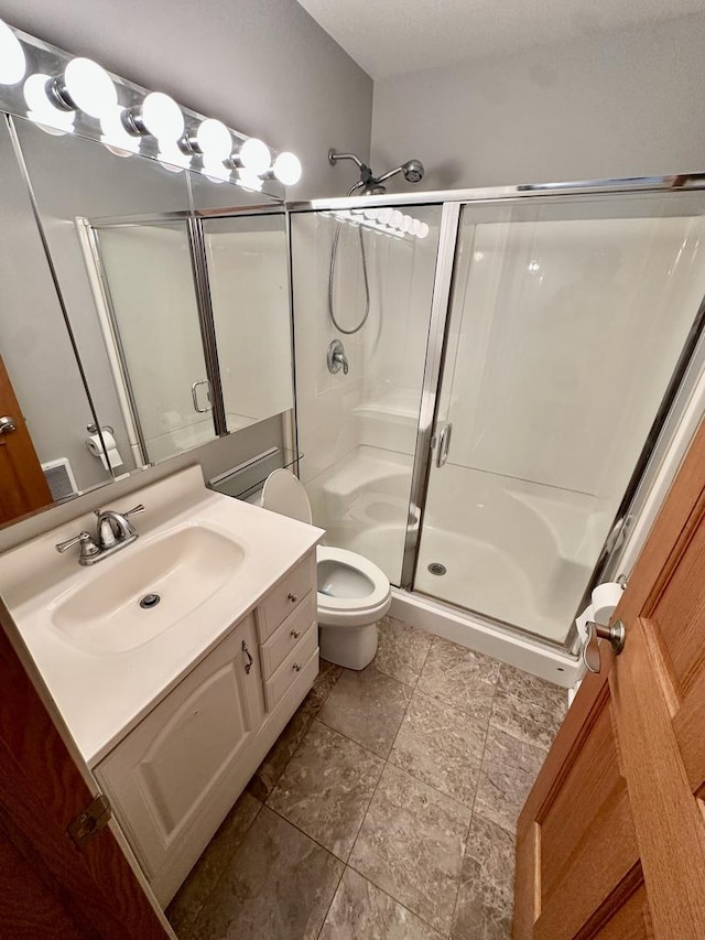35 Montego Colony Unit 1, Fox Lake, IL 60020 - full bathroom with a stall shower, vanity, toilet, and stone finish flooring