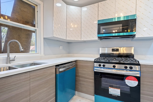 715 E 105th Pl, Chicago, IL 60628 - kitchen featuring appliances with stainless steel finishes, modern cabinets, light countertops, and healthy amount of natural light