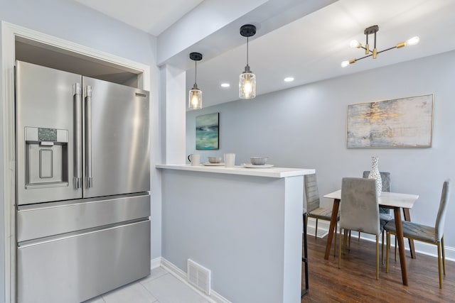 715 E 105th Pl, Chicago, IL 60628 - kitchen featuring stainless steel refrigerator with ice dispenser, baseboards, a peninsula, a chandelier, and recessed lighting