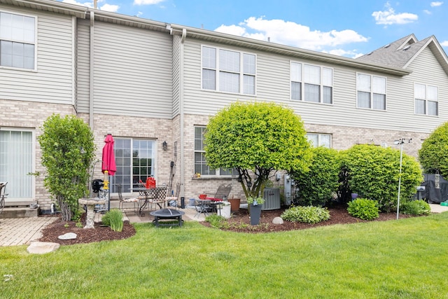 9051 Mansfield Dr, Tinley Park, IL 60487 - rear view of property featuring a yard, brick siding, a patio area, and central AC