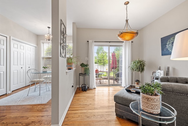 9051 Mansfield Dr, Tinley Park, IL 60487 - living room with light wood-type flooring, a chandelier, healthy amount of natural light, and baseboards