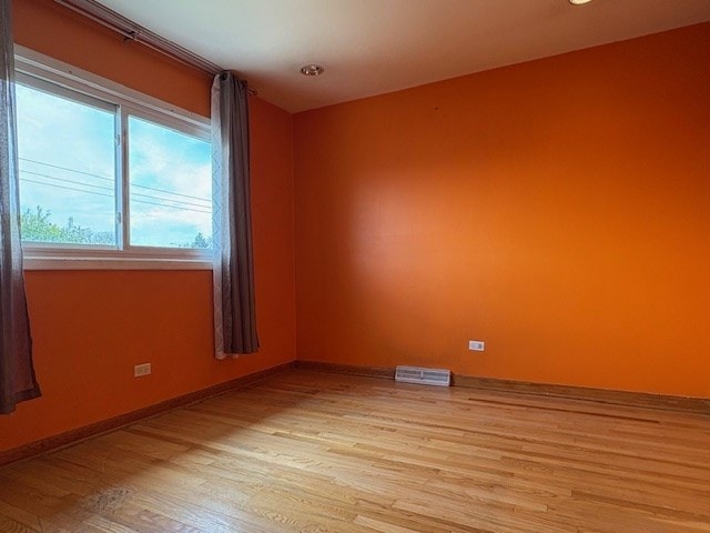 9865 Garden Ct, Schiller Park, IL 60176 - empty room with light wood finished floors and baseboards