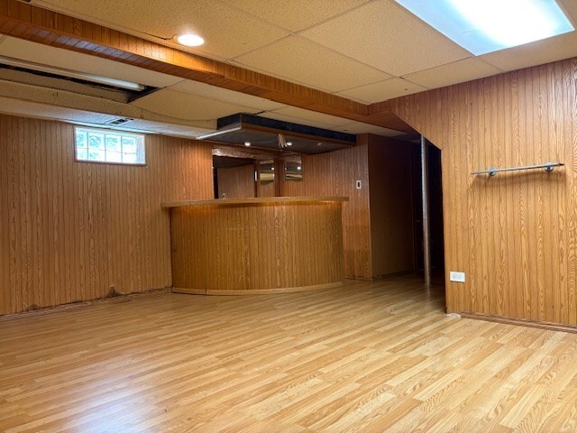 9865 Garden Ct, Schiller Park, IL 60176 - below grade area with wood finished floors, a bar, and wooden walls