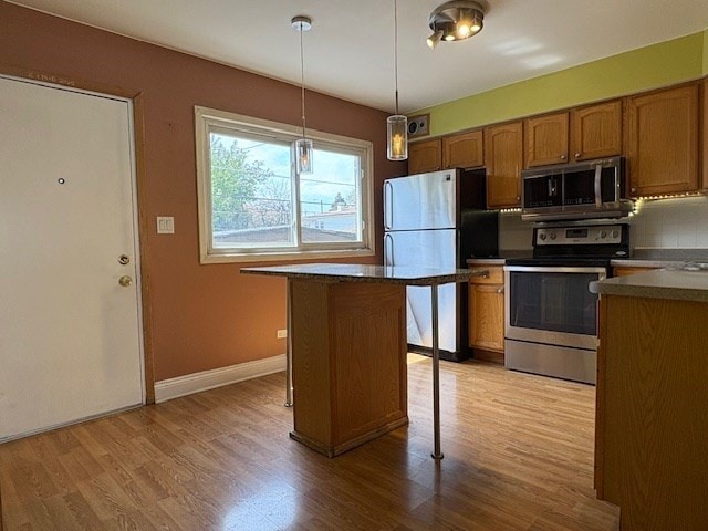 9865 Garden Ct, Schiller Park, IL 60176 - kitchen with appliances with stainless steel finishes, brown cabinetry, baseboards, and light wood-style floors