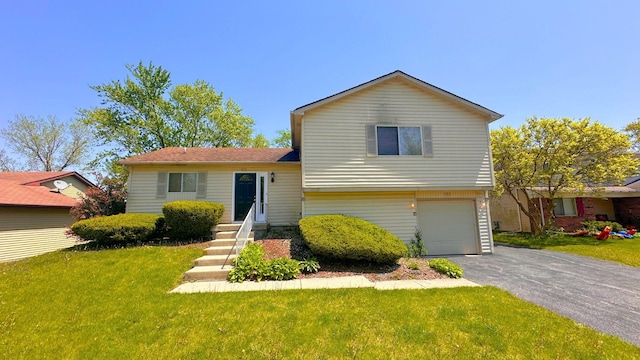 tri-level home with a front lawn, a garage, and asphalt driveway