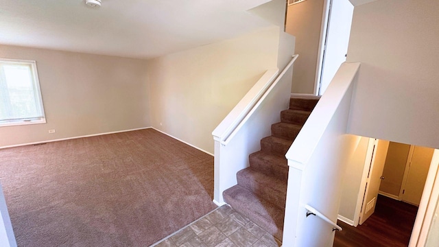 stairs featuring carpet flooring and baseboards