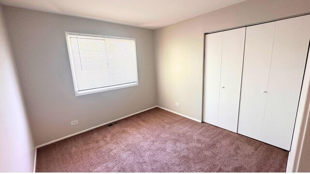 unfurnished bedroom featuring carpet, a closet, and baseboards