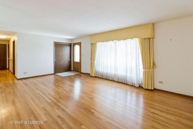 1527 W Amelia Ln, Addison, IL 60101 - unfurnished living room featuring light wood-style flooring and baseboards