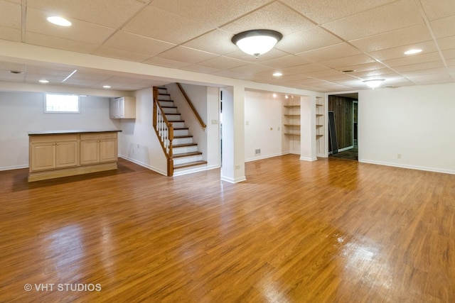 1527 W Amelia Ln, Addison, IL 60101 - basement with light wood-type flooring, a drop ceiling, built in shelves, baseboards, and stairway