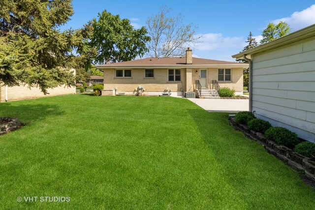 1527 W Amelia Ln, Addison, IL 60101 - back of house with a lawn, a chimney, and brick siding