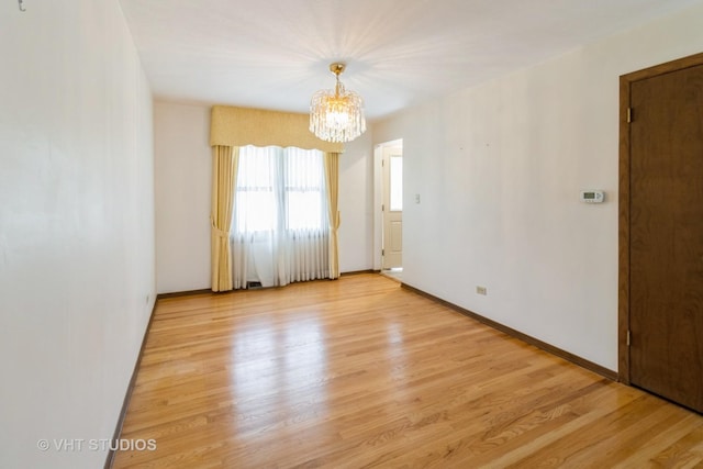 1527 W Amelia Ln, Addison, IL 60101 - unfurnished room with a chandelier, light wood-style flooring, and baseboards